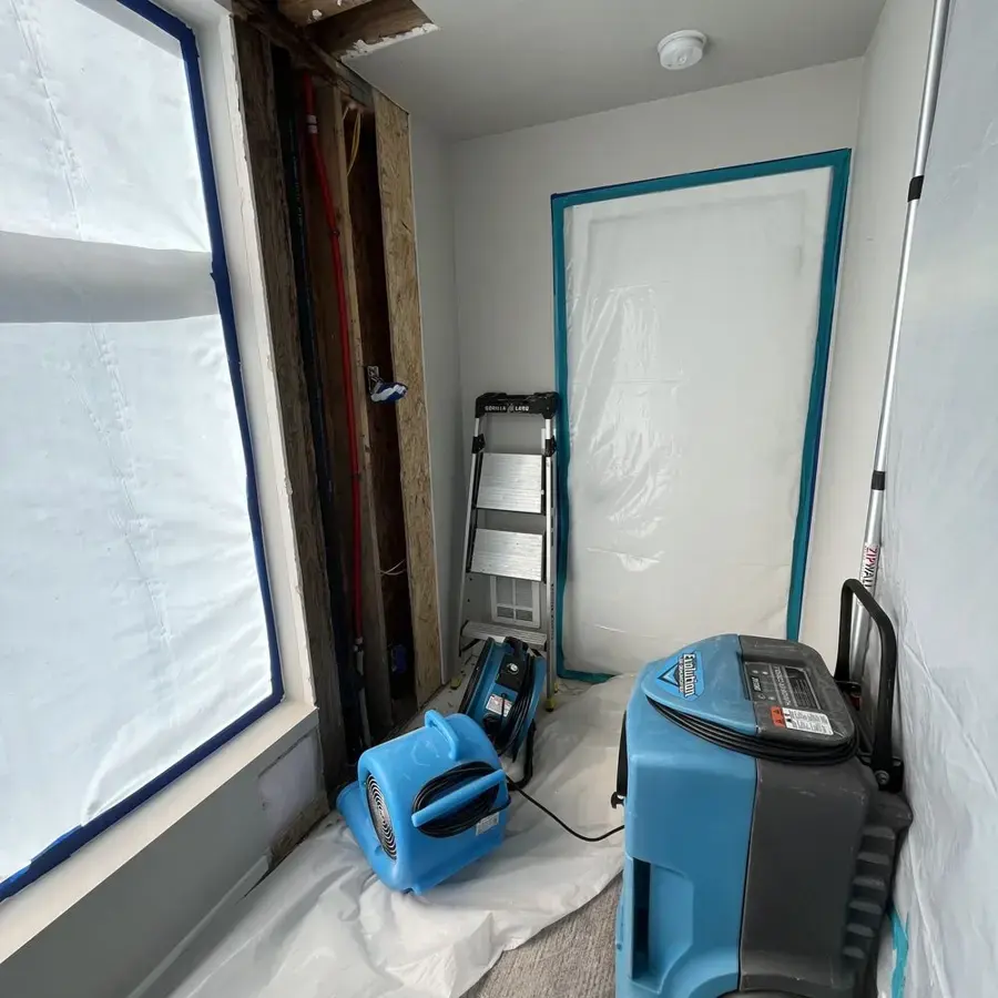 Containment plastic, an air mover and a dehumidifier set up during a Redmond dry-out