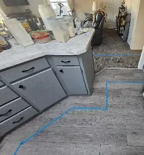 Blue tape marking the wet edge of a kitchen floor during a Redmond moisture mapping visit